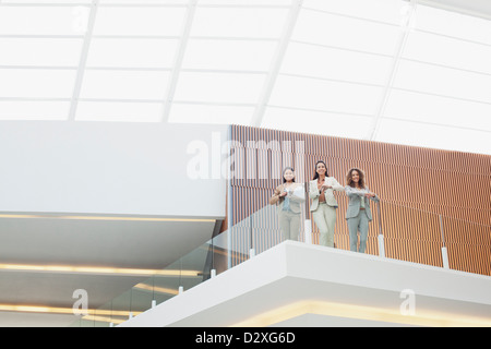 Porträt des Lächelns Geschäftsfrauen auf Balkon im modernen Büro Stockfoto
