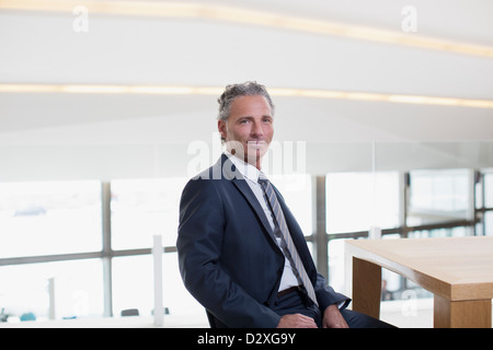 Porträt von lächelnden Geschäftsmann am Tisch Stockfoto