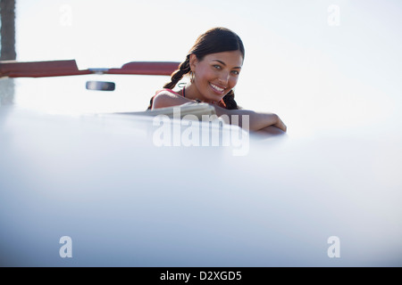 Lächelnde Frau gelehnt aus Cabrio Stockfoto