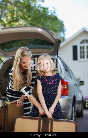 Mutter und Tochter mit Gepäck zum Auto Stockfoto