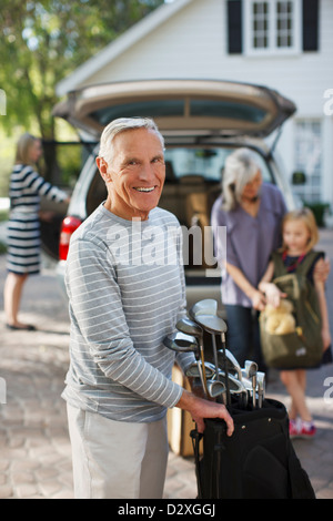 Älterer Mann mit Golfschläger in Tasche Stockfoto