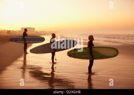 Surfer hält Boards am Strand Stockfoto