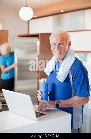 Älterer Mann mit Laptop nach Training Stockfoto