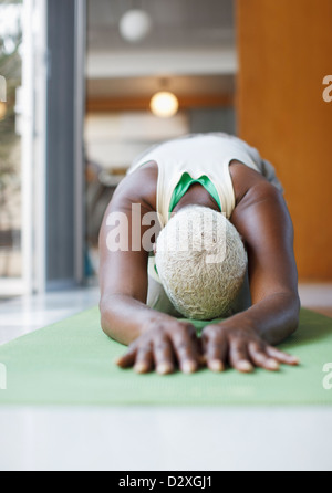 Ältere Frau praktizieren Yoga im Wohnzimmer Stockfoto