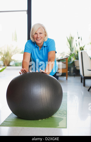 Ältere Frau mit Gymnastikball im Haus Stockfoto