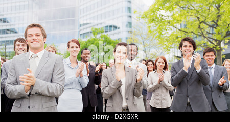 Porträt von Händeklatschen Geschäftsleute in Menge Stockfoto