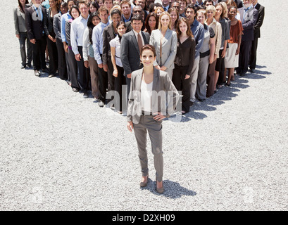 Porträt von zuversichtlich Geschäftsfrau mit Team von Geschäftsleuten im Hintergrund Stockfoto