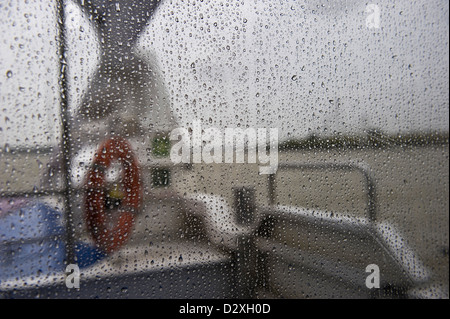 Blick durch das Fenster regen bedeckt von einem Thames Clipper auf der Themse, London, UK Stockfoto
