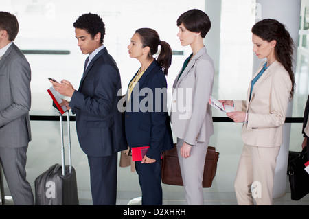 Geschäftsleuten stehen in Warteschlange am Flughafen Stockfoto