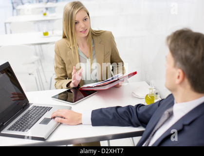 Unternehmer und Unternehmerin diskutieren Papierkram Stockfoto