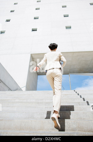 Geschäftsfrau, die städtischen Treppe hinauf hetzen Stockfoto