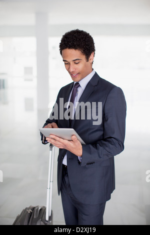 Geschäftsmann mit Koffer mit digital-Tablette in Flughafen Stockfoto