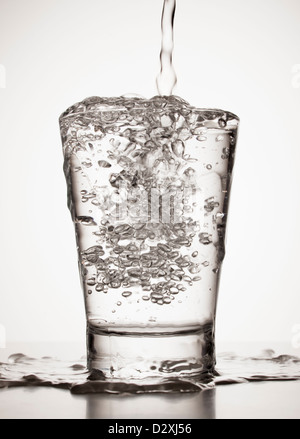 Wasser überfüllt aus Glas Stockfoto