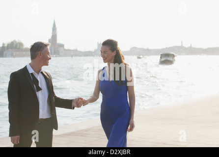 Gut gekleidete paar Hand in Hand im Waterfront in Venedig Stockfoto