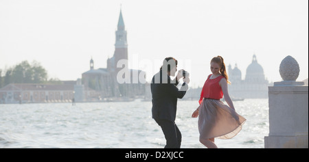 Mann filmt Frau im Waterfront in Venedig Stockfoto