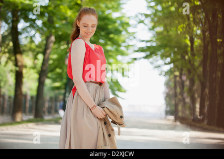 Lächelnde Frau blickte im park Stockfoto