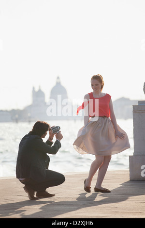 Mann Videoing lächelnde Frau im Waterfront in Venedig Stockfoto