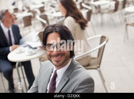 Porträt von lächelnden Geschäftsmann im Straßencafé Stockfoto