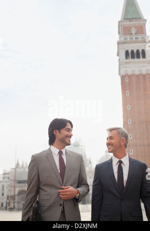 Lächelnde Geschäftsleute zu Fuß in den Markusplatz in Venedig Stockfoto