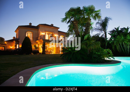 Luxus-Schwimmbad und Villa nachts beleuchtet Stockfoto