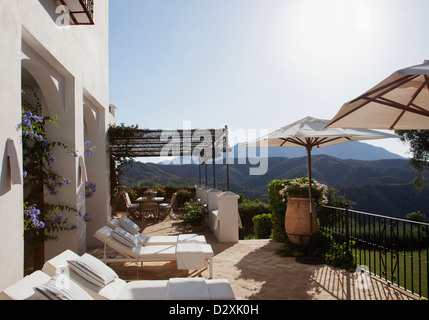 Liegestühle und Sonnenschirme auf Balkon Luxushotels Stockfoto