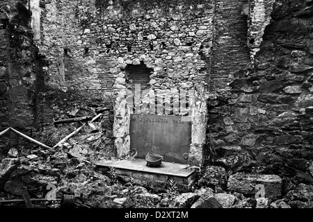 Innere des zerstörten Haus in Oradour-Sur-Glane, Frankreich. Alles, die was übrig bleibt sind einige Wände und ein Kamin und Kochtopf. Stockfoto