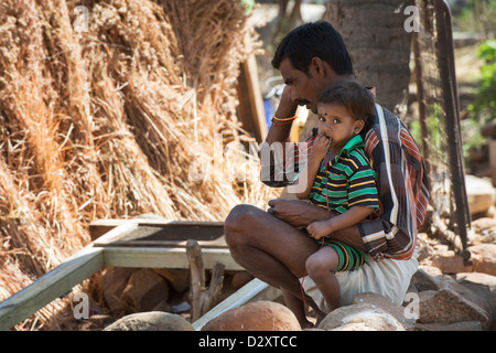 Ländliche indischer Vater und Sohn sitzen in einem indischen Dorf. Andhra Pradesh, Indien Stockfoto