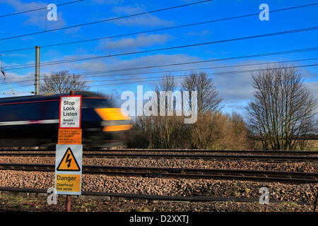 Sehen hören Eisenbahn Warnschild mit rasenden Zug an unbemannten Schranke überqueren Cambridgeshire England UK zu stoppen Stockfoto