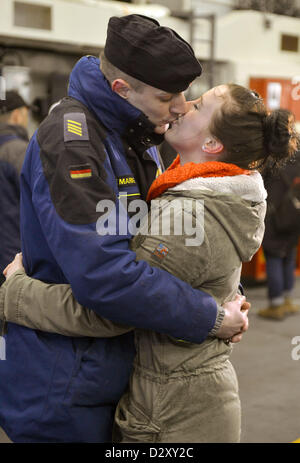 Petty Officer Third Class Albert Liebert küsst seine Anneke Reents als die Fregatte "Emden" und Korvetten "Oldenburg" und "Braunschweig" verlassen der Marinestützpunkt in Wilhelmshaven, Deutschland, 4. Februar 2013. Nach 30 Jahren Militärdienst verlässt die "Emden" für seine letzte Mission. Es führt eine Ausbildung Formation zusammen mit Korvetten "Oldenburg" und "Braunschweig". Foto: CARMEN JASPERSEN Stockfoto