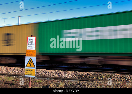 Sehen hören Eisenbahn Warnschild mit rasenden Zug an unbemannten Schranke überqueren Cambridgeshire England zu stoppen Stockfoto