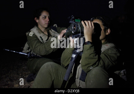 Eine israelische Soldatin aus dem Eitam Field Intelligence Bataillon 727. des Combat Intelligence Collection Corps, die während des Vortrainings in der Nacht nahe der Grenze zu Ägypten in der südlichen Negev-Wüste Israel ein Nachtsichtfernglas verwendete Stockfoto