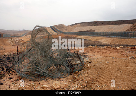 Blick auf den Zaun entlang der trostlosen Straße 10, die sich parallel zur Grenze zu Ägypten in der Negev-Wüste, Israel, erstreckt. Nach einem militärischen Sicherheitsratgeberin sind die gesamten 113 Meilen für den zivilen Verkehr fast dauerhaft gesperrt Stockfoto