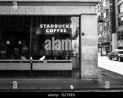 ein Mann sitzt im Starbucks Kaffee in London Stockfoto