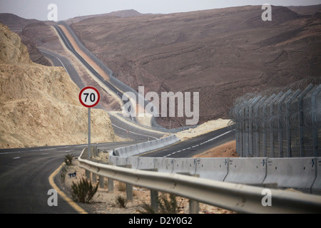 Blick auf den Zaun entlang der Straße 12, der sich parallel zur Grenze zu Ägypten in der Negev-Wüste, Israel, erstreckt. Stockfoto