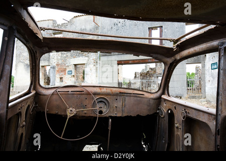 Eine Außenansicht eines ausgebrannten alten Autos im zerstörten französischen Dorf Oradour-Sur-Glane. Stockfoto