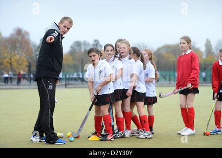 Ein Spiele-Lehrer weist Mädchen während Hockeytraining an Pasteten Grammar School in Cheltenham, Gloucestershire UK Stockfoto