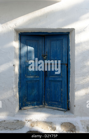 Mykonos. Cyclades. Grecce. Ein weiß getünchten Haus mit blauen Doppeltüren in den Hintergassen von Chora, der Hauptstadt von Mykonos. Stockfoto