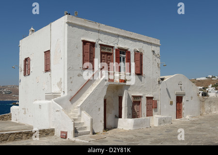 Mykonos Cyclades. Grecce. Weiß getünchten zweistöckiges Haus mit braunen, roten Türen und Fensterläden am Meer, Chora. Stockfoto
