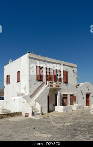 Mykonos Cyclades. Grecce. Weiß getünchten zweistöckiges Haus mit braunen, roten Türen und Fensterläden am Meer, Chora. Stockfoto