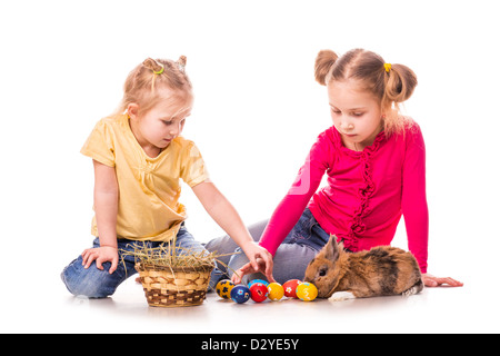 Zwei glückliche Kinder mit Osterhasen und Eiern isoliert auf weiss. Frohe Ostern Stockfoto