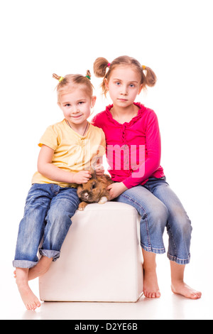 Zwei glückliche Kinder mit Osterhasen und Eiern isoliert auf weiss. Frohe Ostern Stockfoto