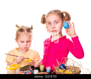 Zwei glückliche Kinder bemalen von Ostereiern isoliert auf weiss. Frohe Ostern Stockfoto