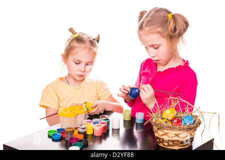 Zwei glückliche Kinder bemalen von Ostereiern isoliert auf weiss. Frohe Ostern Stockfoto