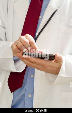 Männlichen Arzt im weißen Kittel ist ein modernes Smartphone-Gerät mit Tocuh Bildschirm verwenden. Stockfoto