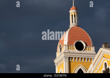 Der Turm an der hellen gelben Fassade der koloniale Kathedrale im Zentrum von Granada Nicaragua vor einem dramatischen Himmel. Stockfoto