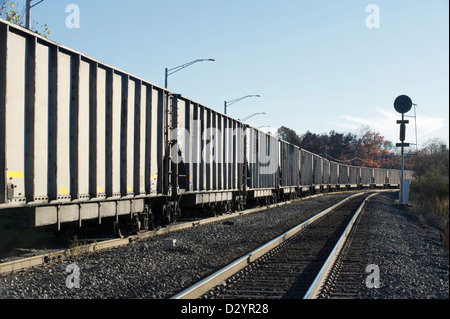 Kohle-Zug Rundung einer Kurve an einem Herbst-Abend, modernen grauen Trichter Autos. Stockfoto