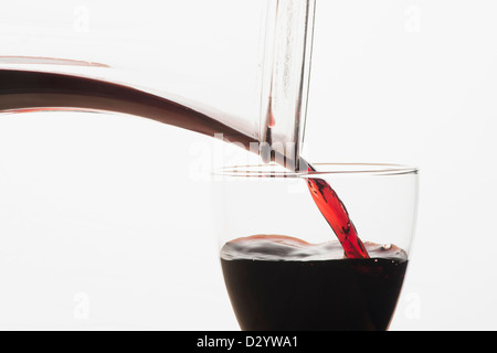 Ein Glas Rotwein aus einer Karaffe gefüllt wird Stockfoto