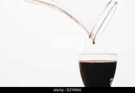 Ein Glas Rotwein aus einer Karaffe gefüllt wird Stockfoto