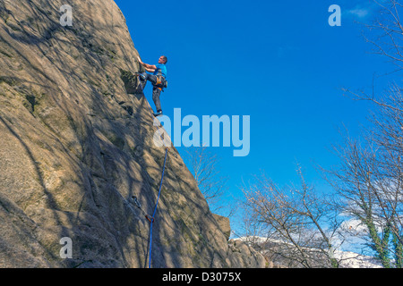 Kletterer in blau auf slabby Felswand Stockfoto