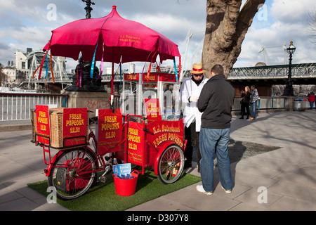 Ein Spaziergang entlang der Themse an der Southbank in London. Ein Popcorn-Verkäufer dient ein Kunde.